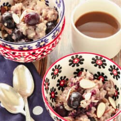 2 patterned bowls filled with breakfast risotto next to a cup of coffee