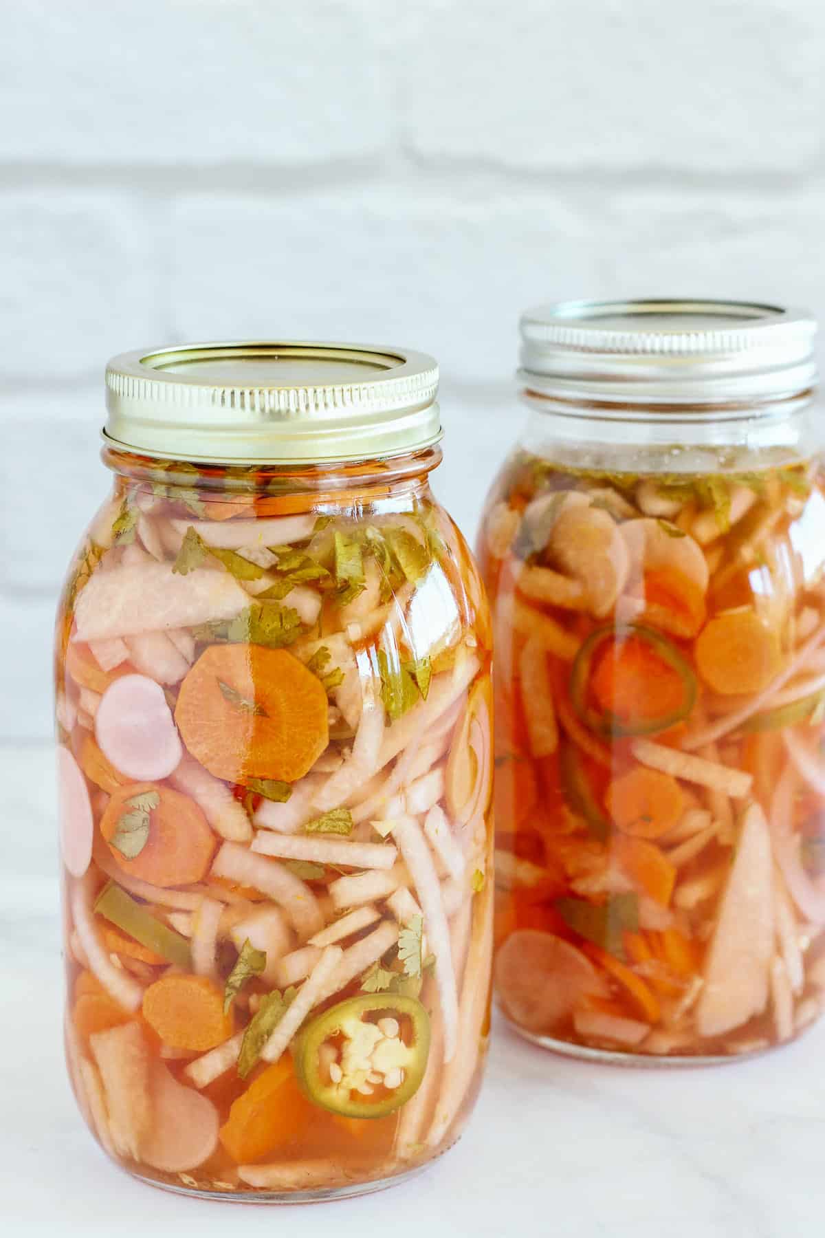 2 large mason jars filled with Mexican pickled vegetables