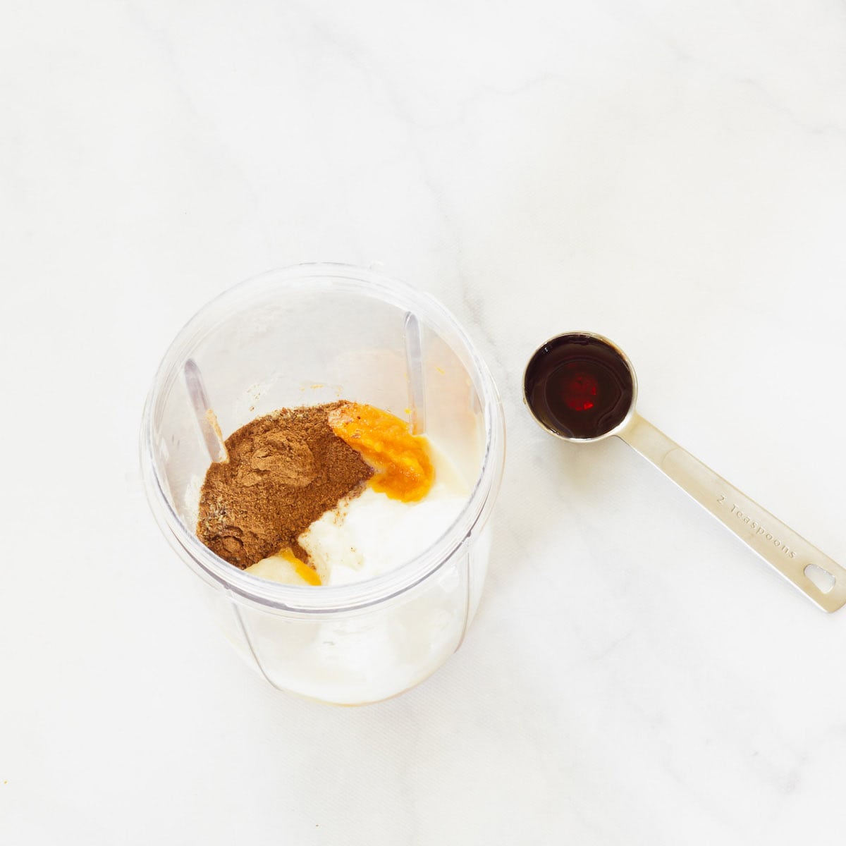 Ingredients for a pumpkin pie smoothie in a blender.