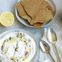 overhead shot of white feta dip with a plate of crackers nearby